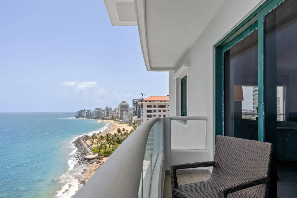 Oceanfront balcony of a Commodore room with sofa bed at Condado Vanderbilt Hotel overlooking the coast.