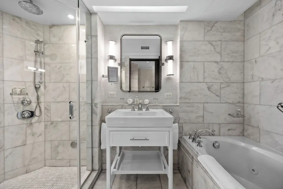 Marble bathroom in a Commodore room with sofa bed at Condado Vanderbilt Hotel with tub and shower.