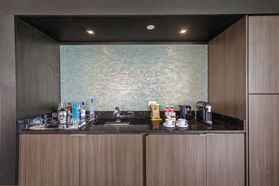 In-room wet bar with sink, glassware, coffee setup, and minibar at Condado Vanderbilt Hotel.