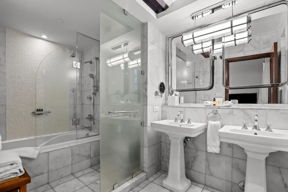 Heritage King Room bathroom with twin sinks and glass shower at Condado Vanderbilt Hotel.