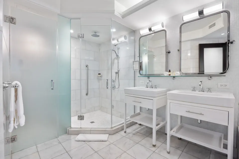 Ocean View Tower King Room bathroom with glass shower and double sinks at Condado Vanderbilt Hotel.