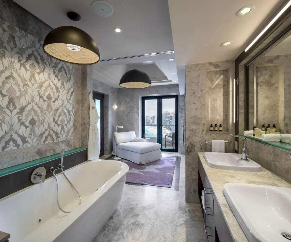 Bathroom and lounge area in the Vanderbilt Oceanfront Two-Bedroom Suite at Condado Vanderbilt Hotel.