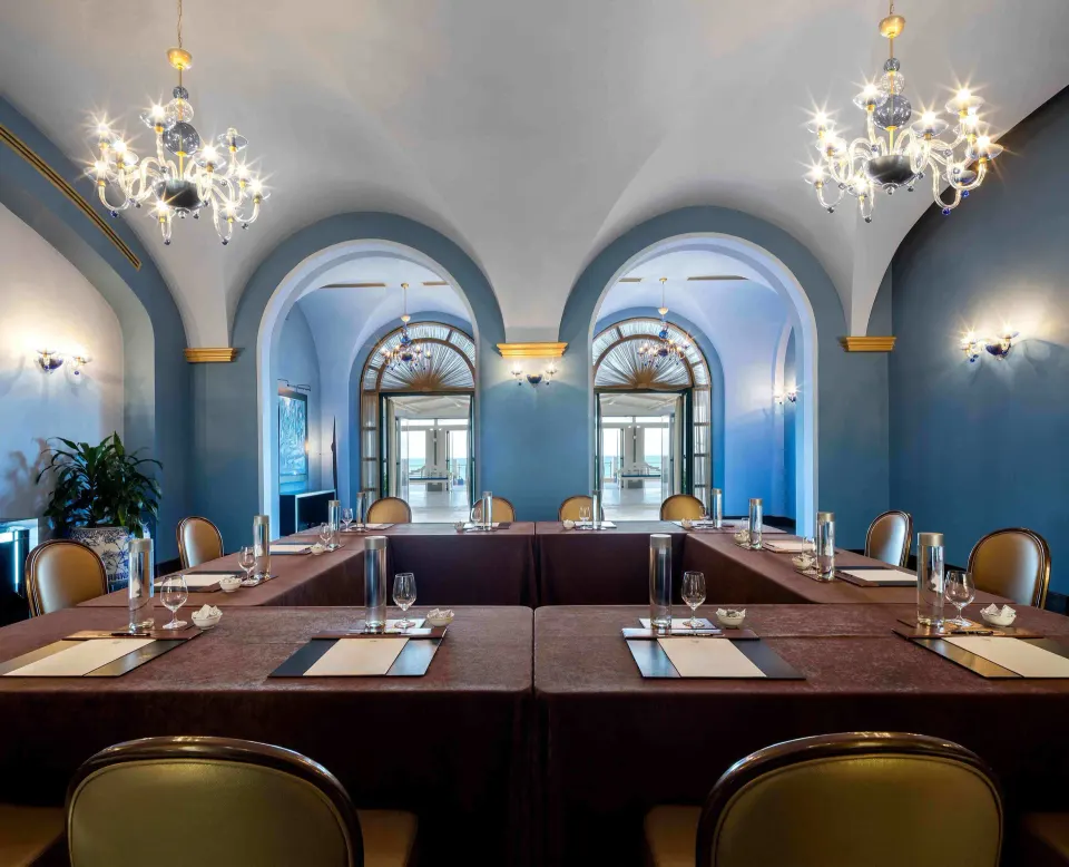 Blue arched meeting room with U-shaped tables at Condado Vanderbilt Hotel.