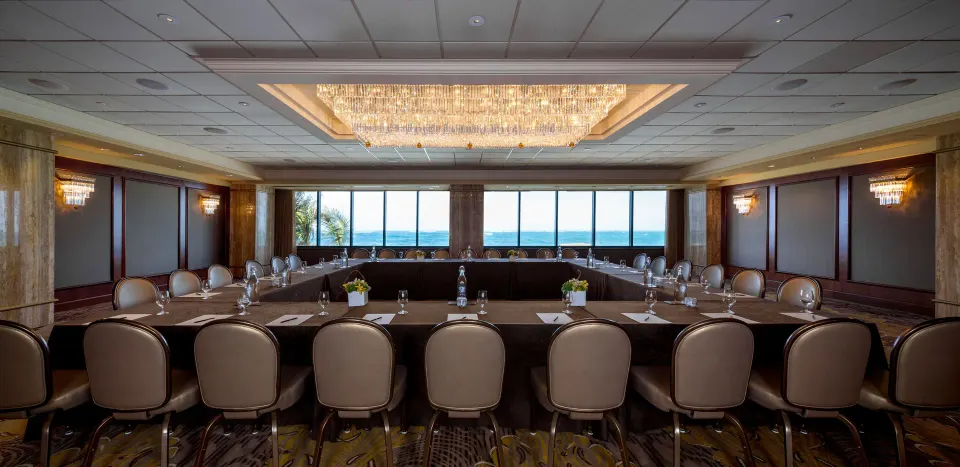 Conference room with long tables and ocean-facing windows at Condado Vanderbilt Hotel.
