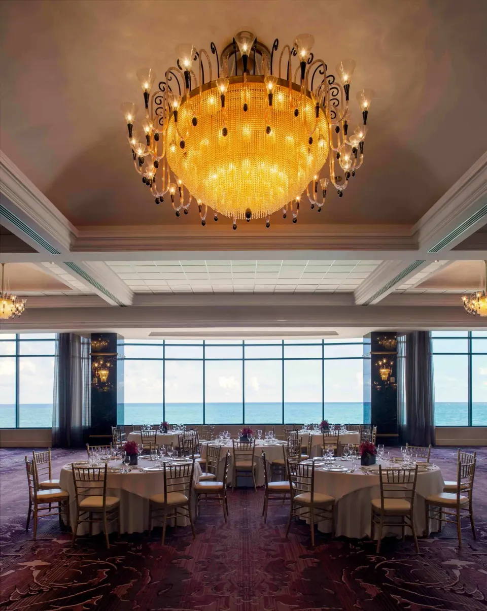Oceanfront ballroom set with round dining tables at Condado Vanderbilt Hotel.