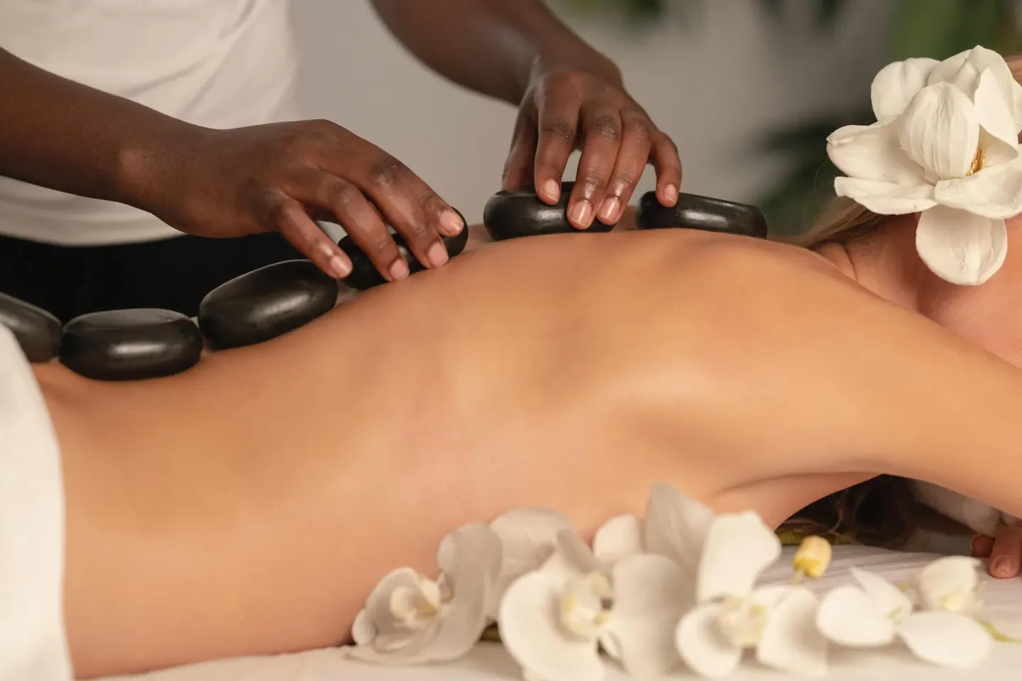 Hot stone massage with white flowers on a spa table at Condovac la Costa.