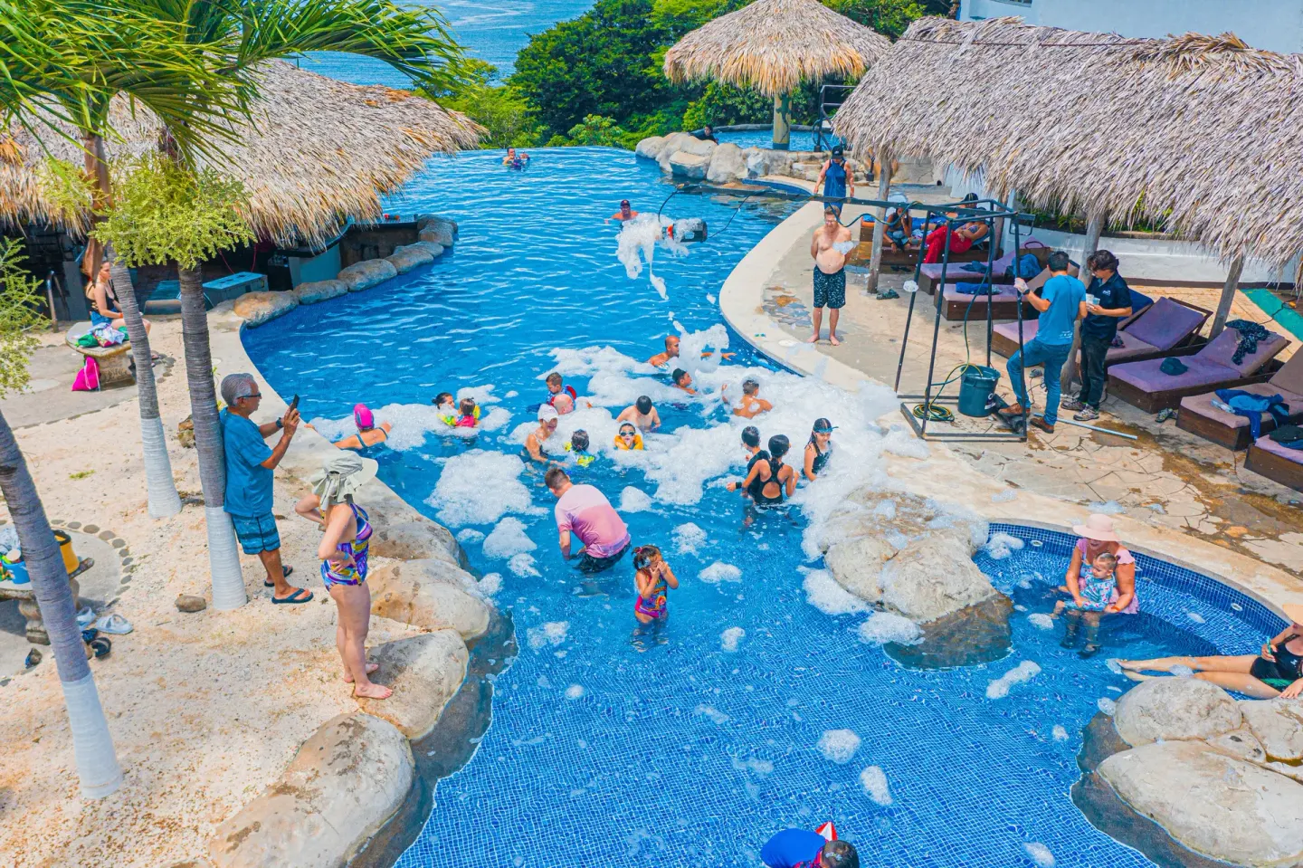 Guests enjoy a foam party in the resort pool at Condovac la Costa.