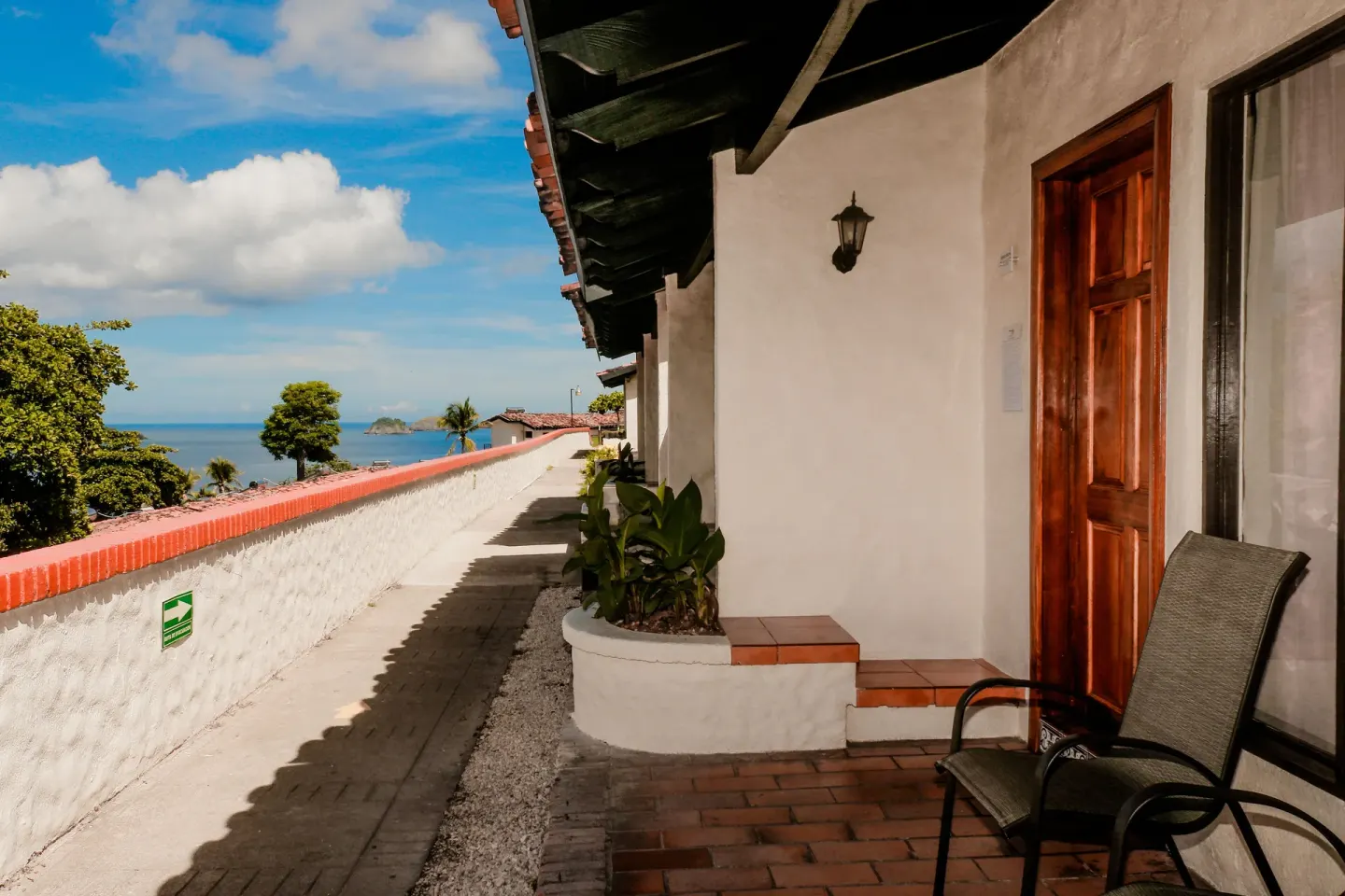 Family Suite exterior entry walkway with ocean in the distance at Condovac la Costa.