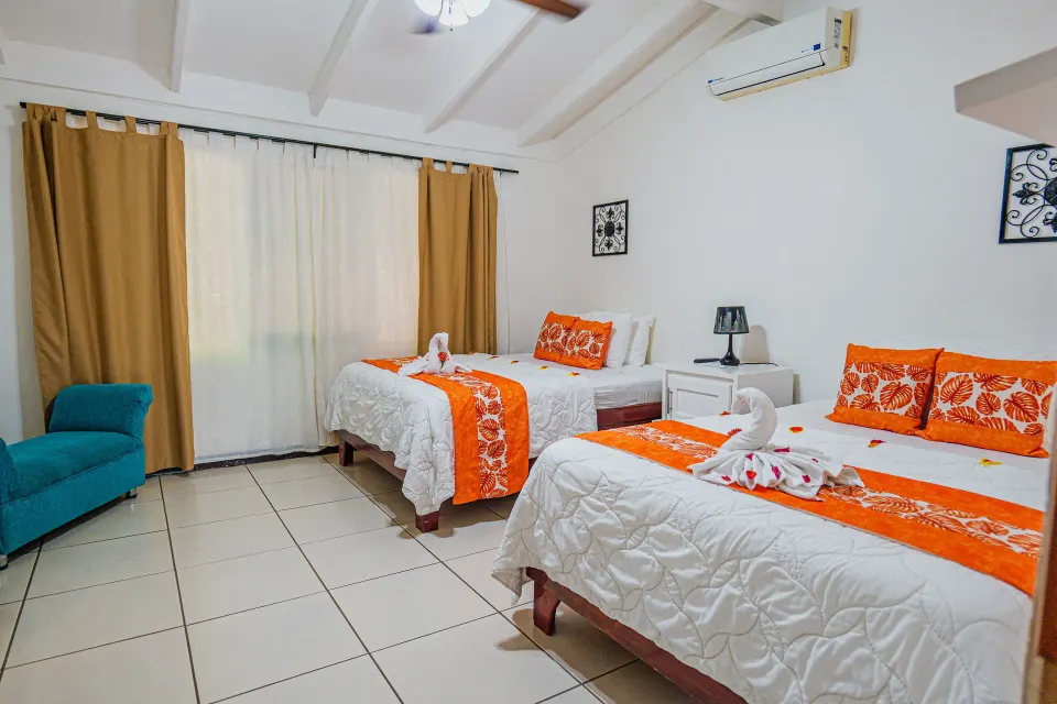Family Suite bedroom with two beds and orange accents at Condovac la Costa.