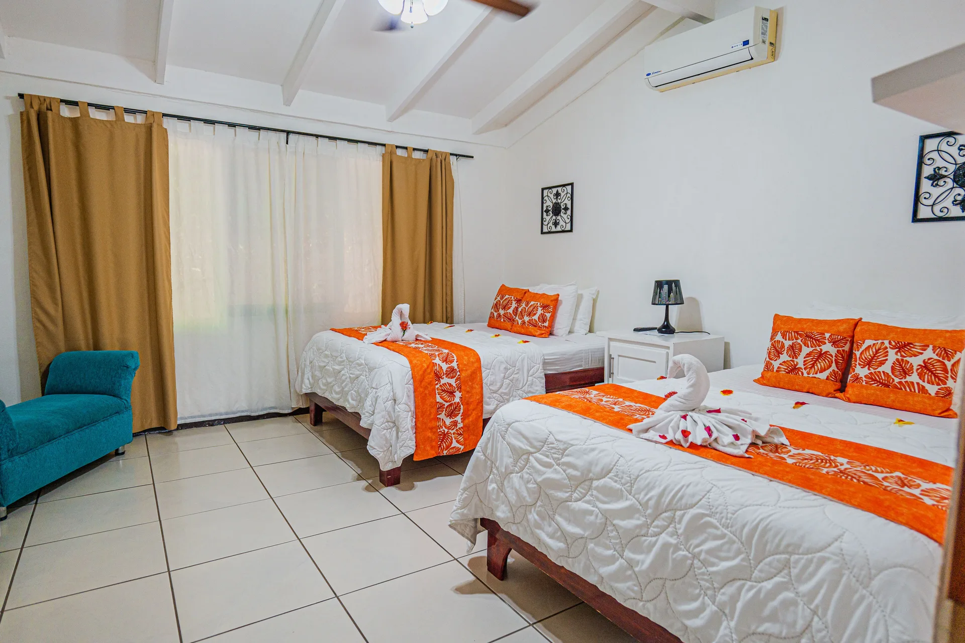Family Suite bedroom with two beds and orange accents at Condovac la Costa.