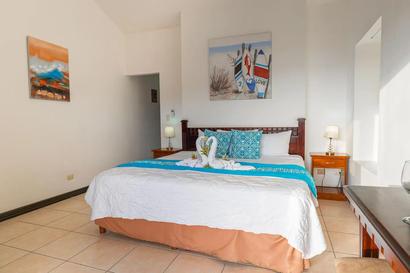 Romantic Studio Suite at Condovac la Costa with a king bed, bedside lamps, and wall art.