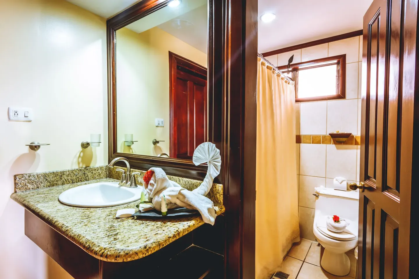 Standard Villa bathroom with granite vanity, sink, shower curtain, and toilet at Condovac la Costa.