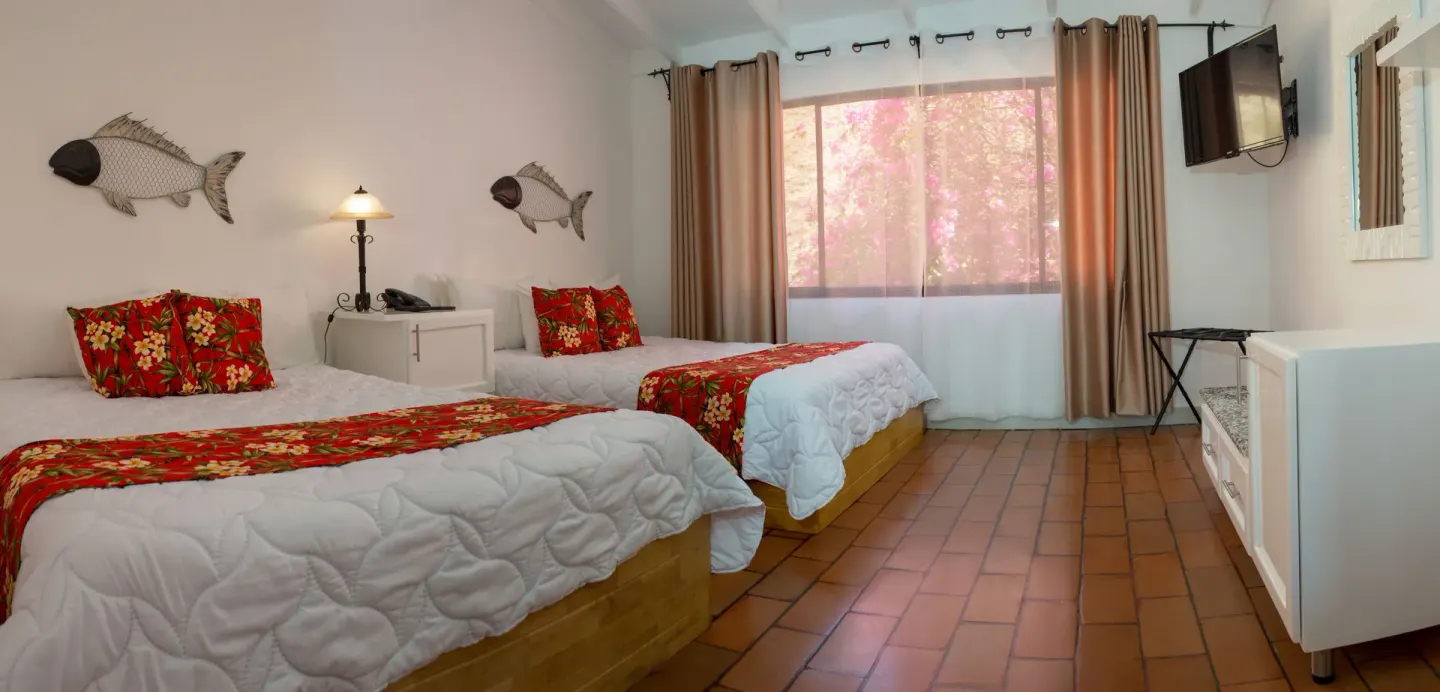 Standard Villa bedroom with two beds and wall-mounted TV at Condovac la Costa.