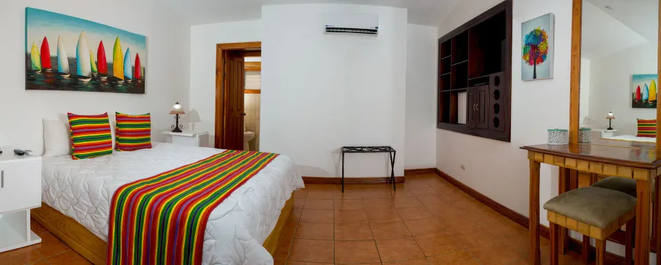 Villa Platinum Ocean View bedroom with striped bedding at Condovac la Costa.