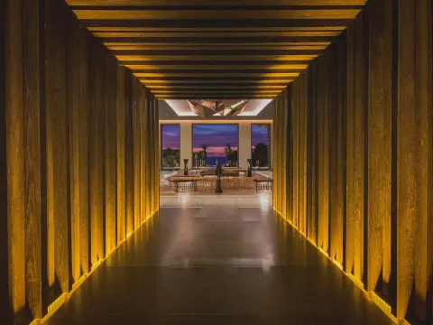 Illuminated wood-lined corridor leading to the lobby at Conrad Punta de Mita.