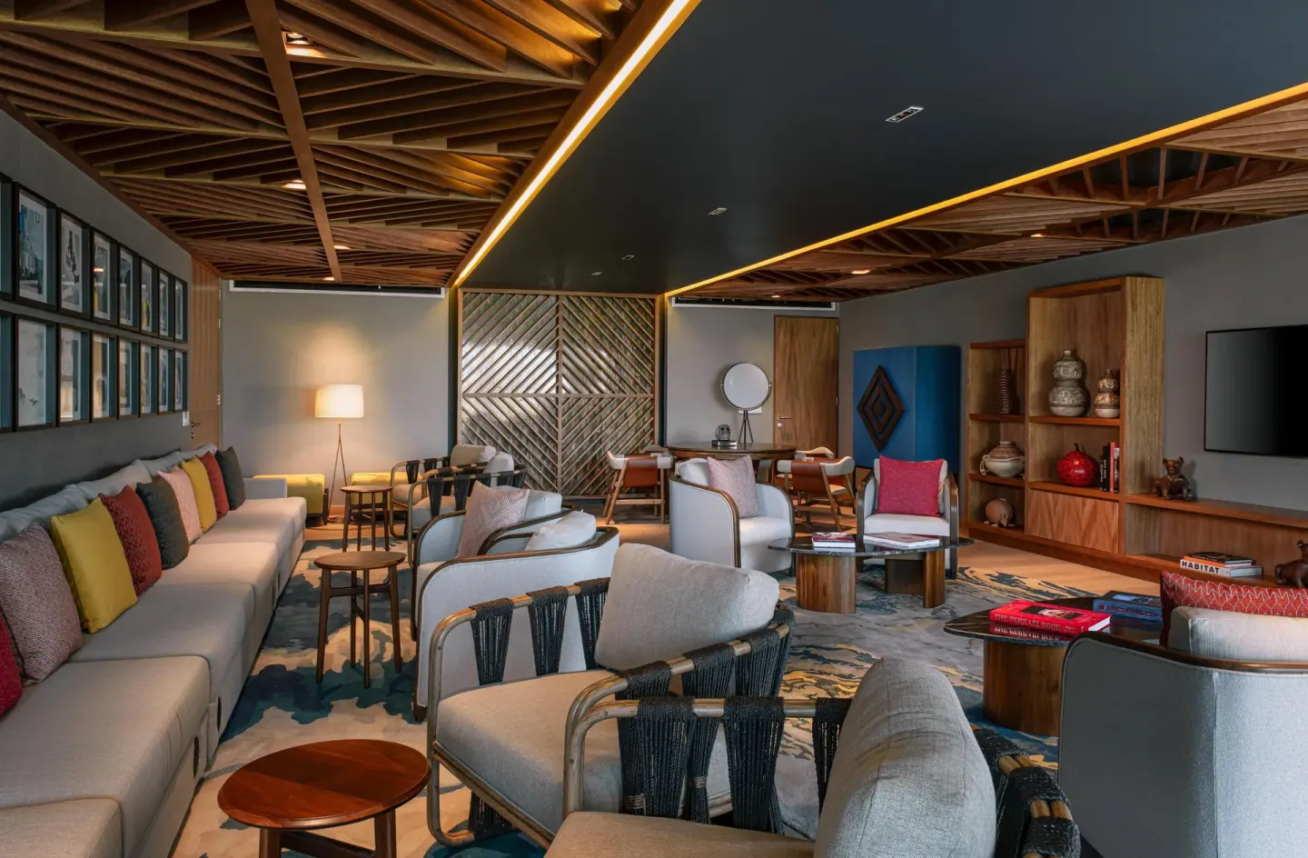 Indoor lounge with sofas, armchairs, wood ceilings, and colorful pillows at Conrad Punta de Mita.