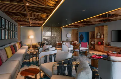Indoor lounge with sofas, armchairs, wood ceilings, and colorful pillows at Conrad Punta de Mita.