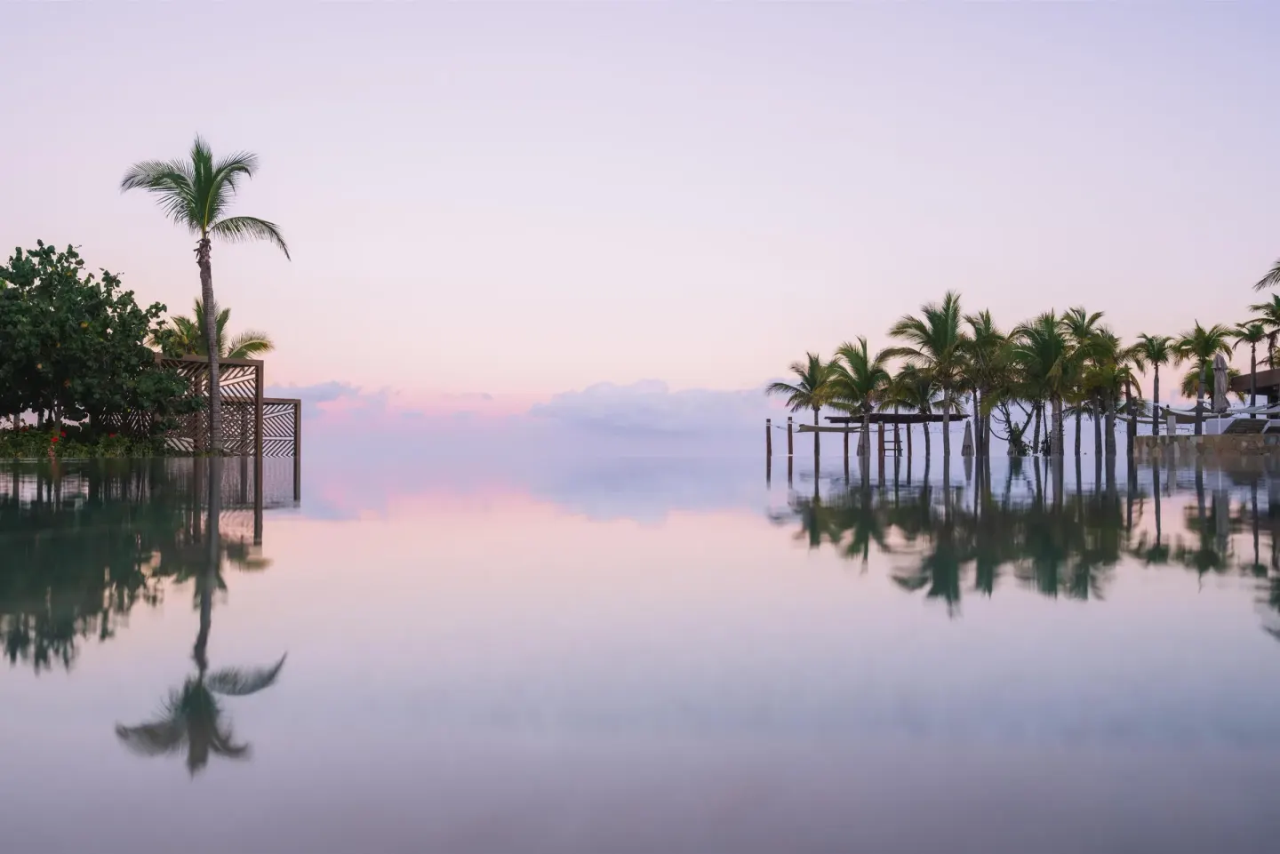 Infinity pool with palm reflections at sunset at Conrad Punta de Mita.