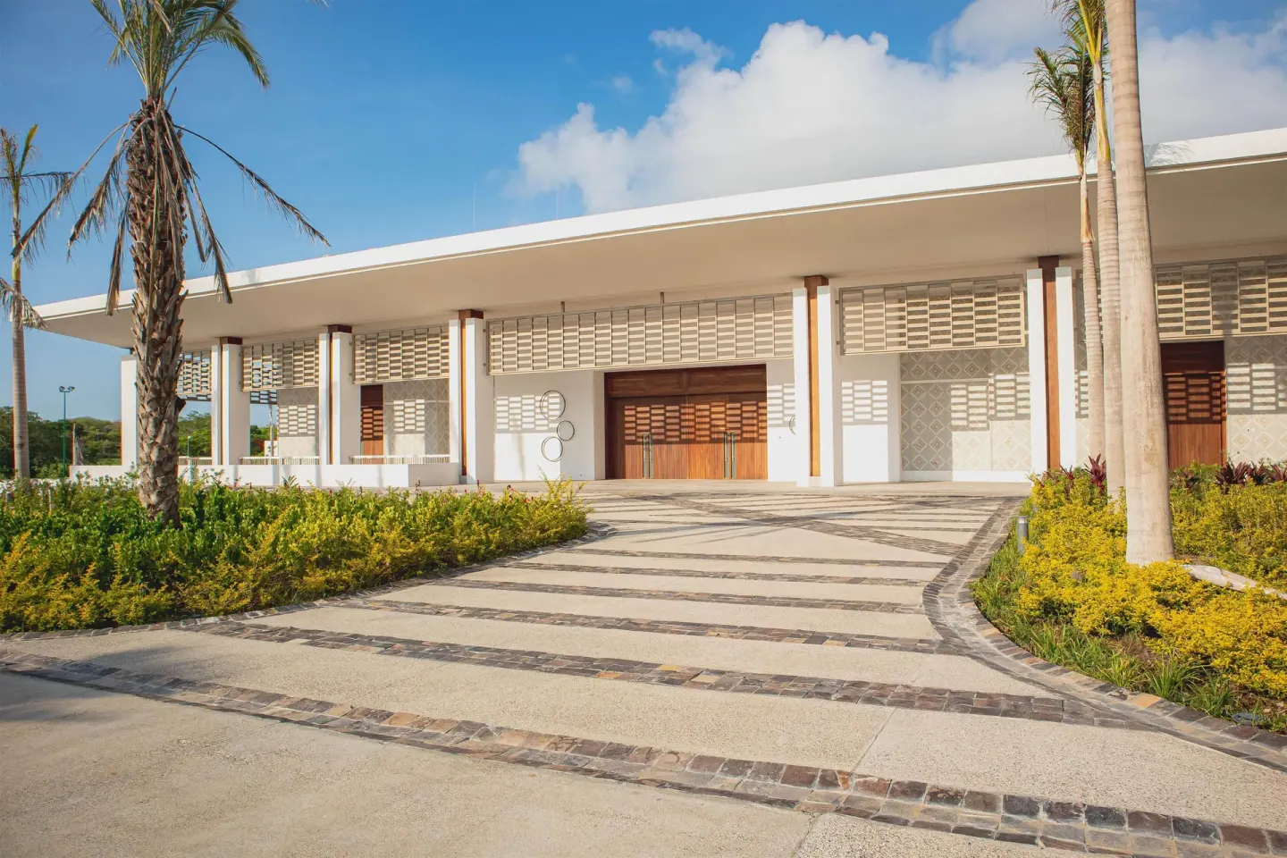 Modern resort entrance with palms and landscaping at Conrad Punta de Mita.