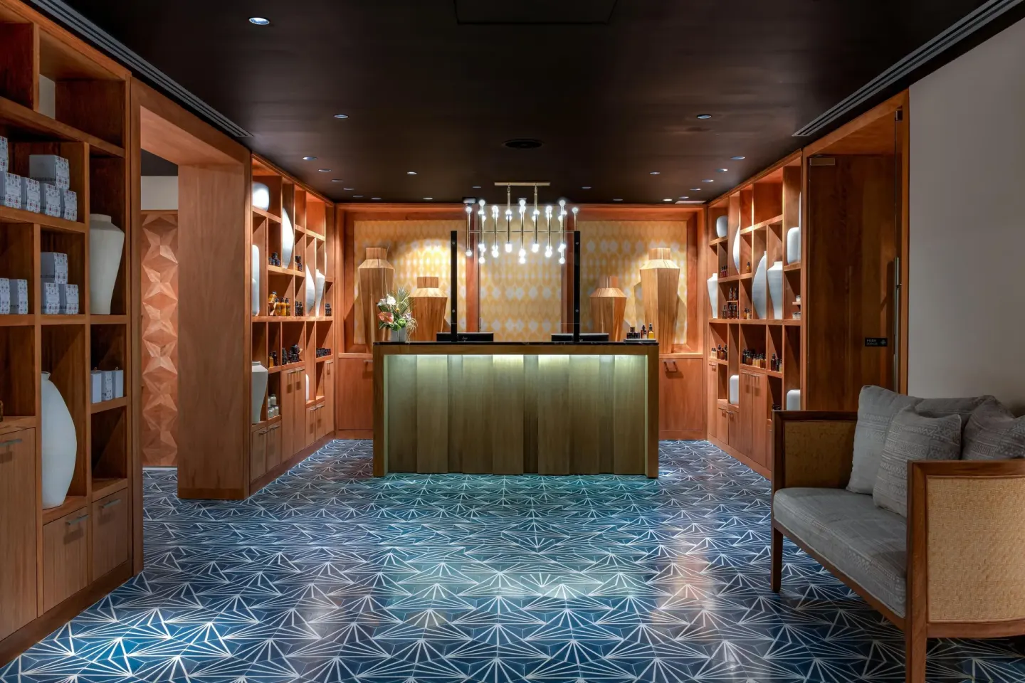 Spa reception desk with wood shelving and patterned carpet at Conrad Punta de Mita.