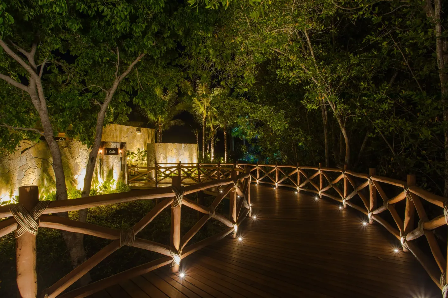 Lighted wooden walkway through trees leading to Codex at Conrad Punta de Mita.