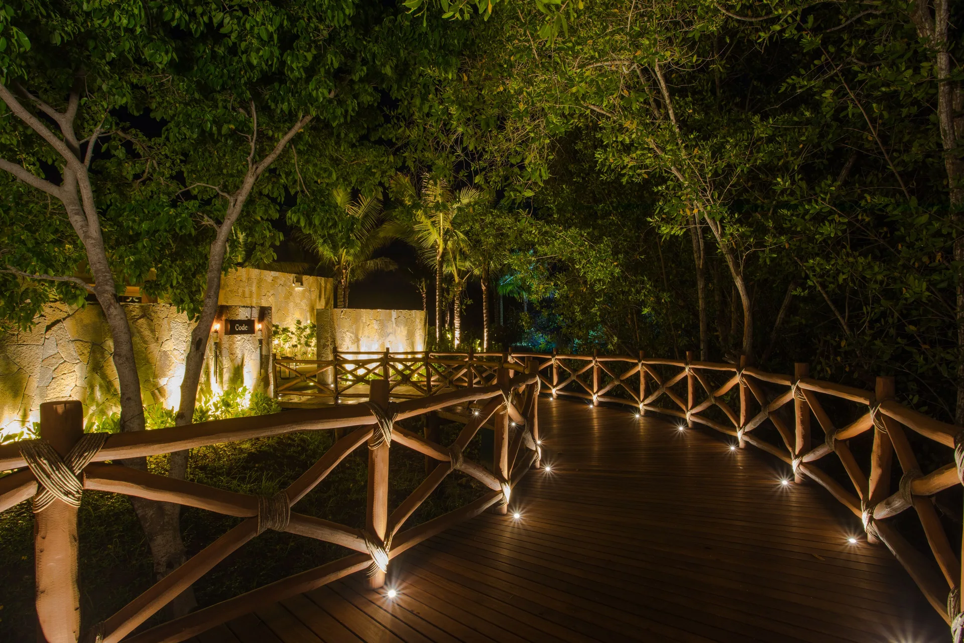 Lighted wooden walkway through trees leading to Codex at Conrad Punta de Mita.