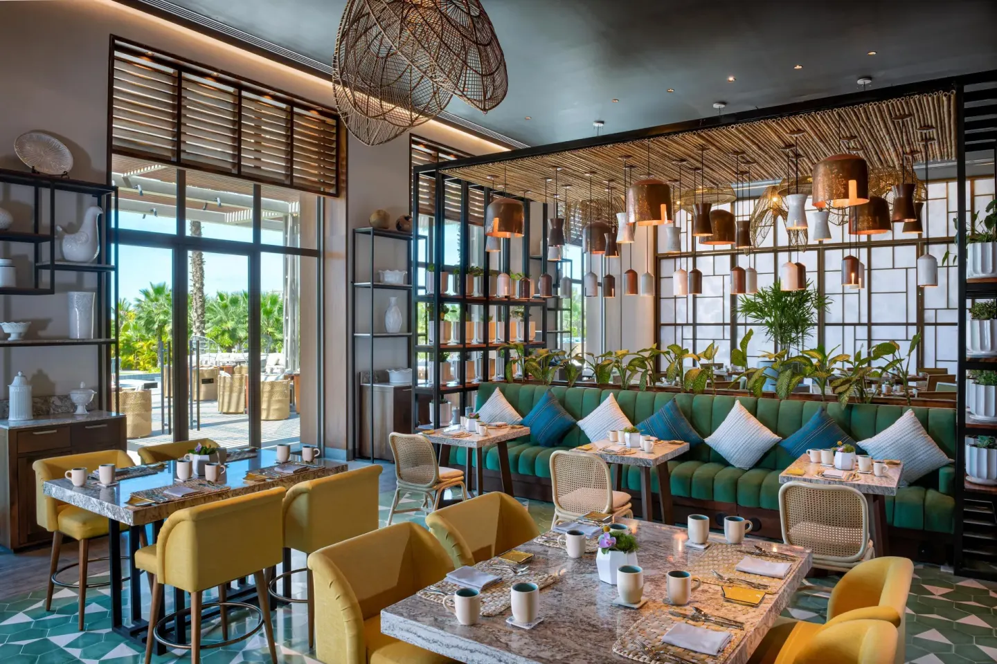 Bright cafe dining room with teal banquettes at Conrad Punta de Mita.