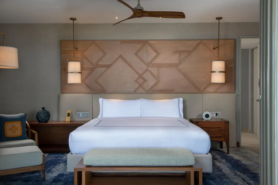 Penthouse king bed with carved headboard at Conrad Punta de Mita.
