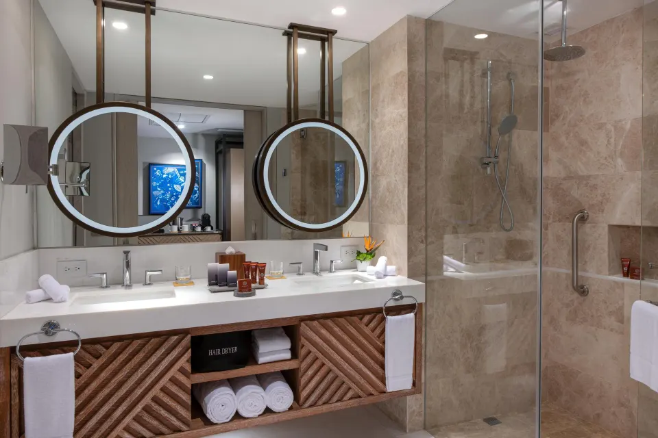Accessible room bathroom with double vanity and roll-in shower at Conrad Punta de Mita.