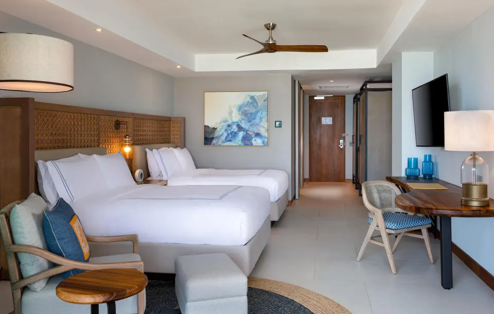 Two-bed accessible room with sitting chair and desk at Conrad Punta de Mita.