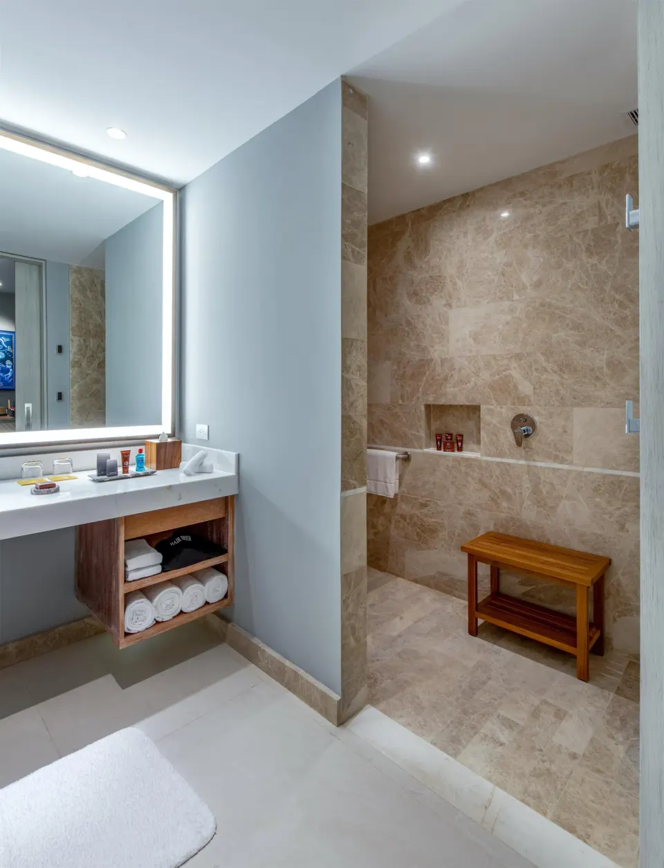 Accessible room bathroom vanity and open roll-in shower with bench at Conrad Punta de Mita.