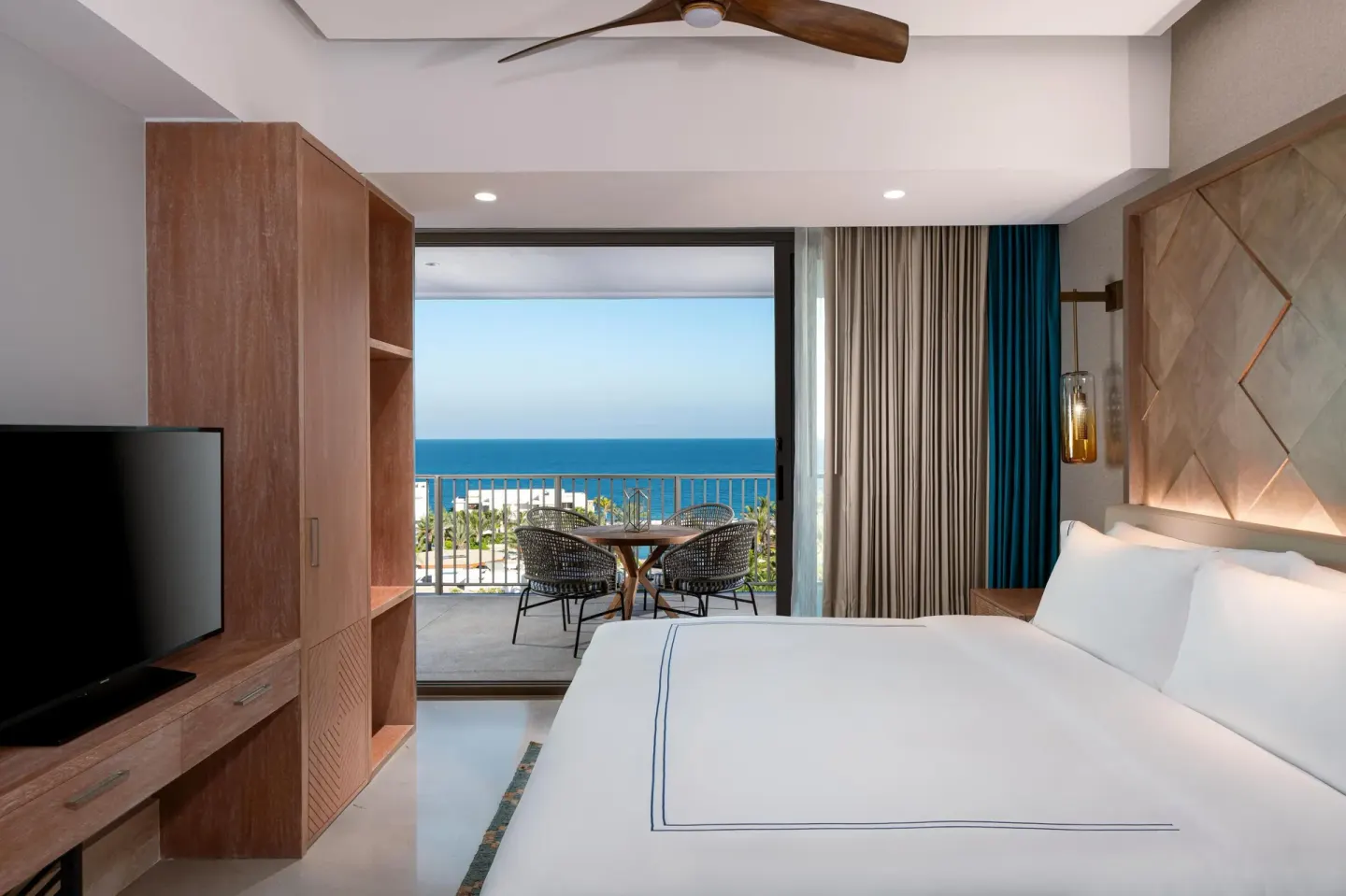 Ocean-view bedroom with king bed and balcony seating at Conrad Punta de Mita.
