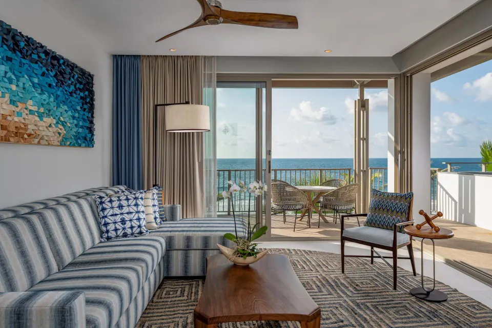 Oceanfront suite living room with sofa, balcony seating, and sea view at Conrad Punta de Mita.