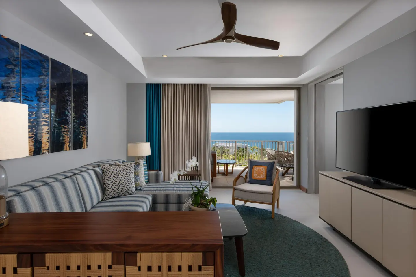 Superior Suite Ocean View living room with sofa, TV, and balcony at Conrad Punta de Mita.