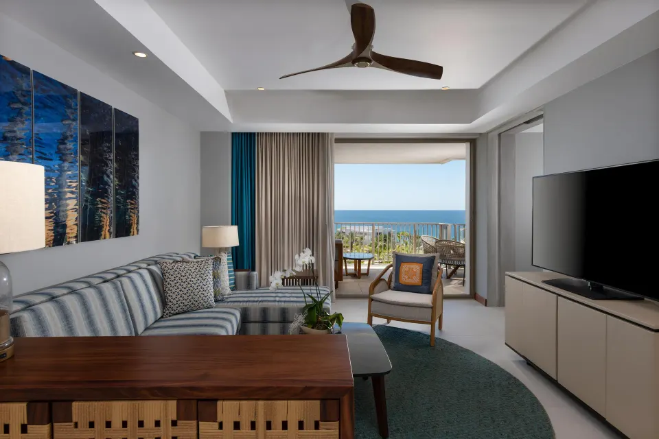 Superior Suite Ocean View living room with sofa, TV, and balcony at Conrad Punta de Mita.
