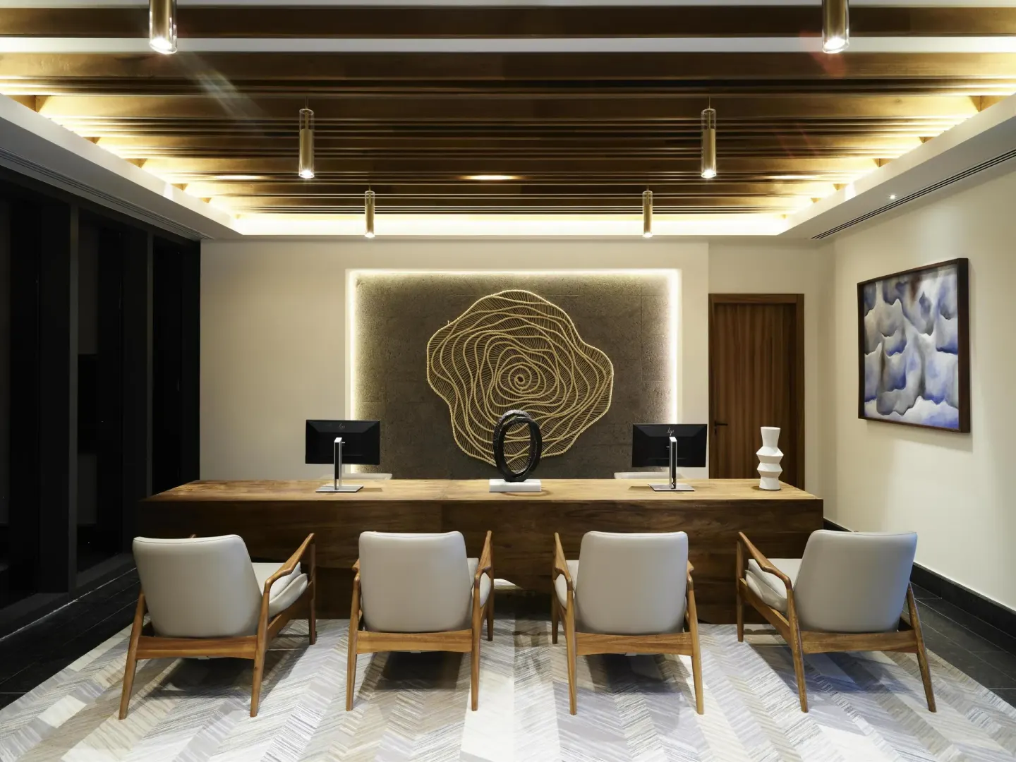 Business center desk with computers, chairs, and wall art at Conrad Tulum Riviera Maya.