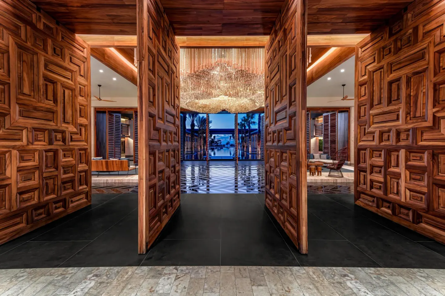 Carved wooden entrance doors opening into the lobby at Conrad Tulum Riviera Maya.