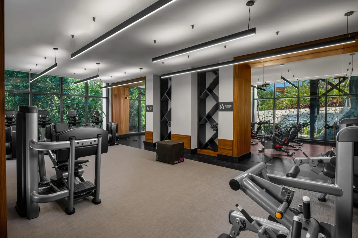 Fitness center with strength machines and mirrored walls at Conrad Tulum Riviera Maya.