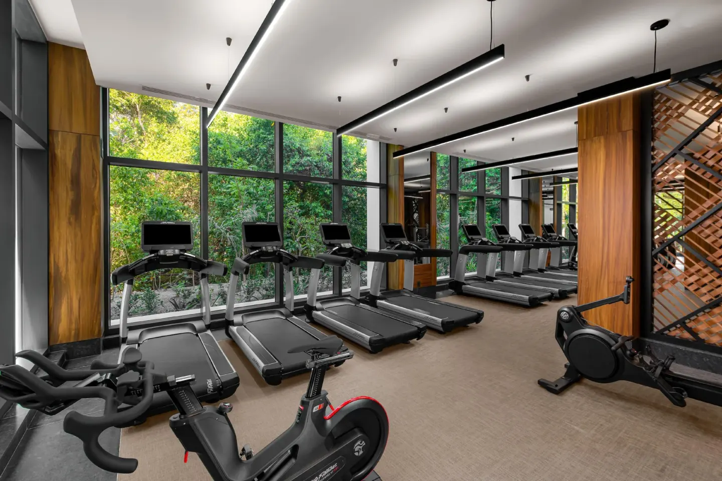 Fitness center treadmills facing large windows at Conrad Tulum Riviera Maya.