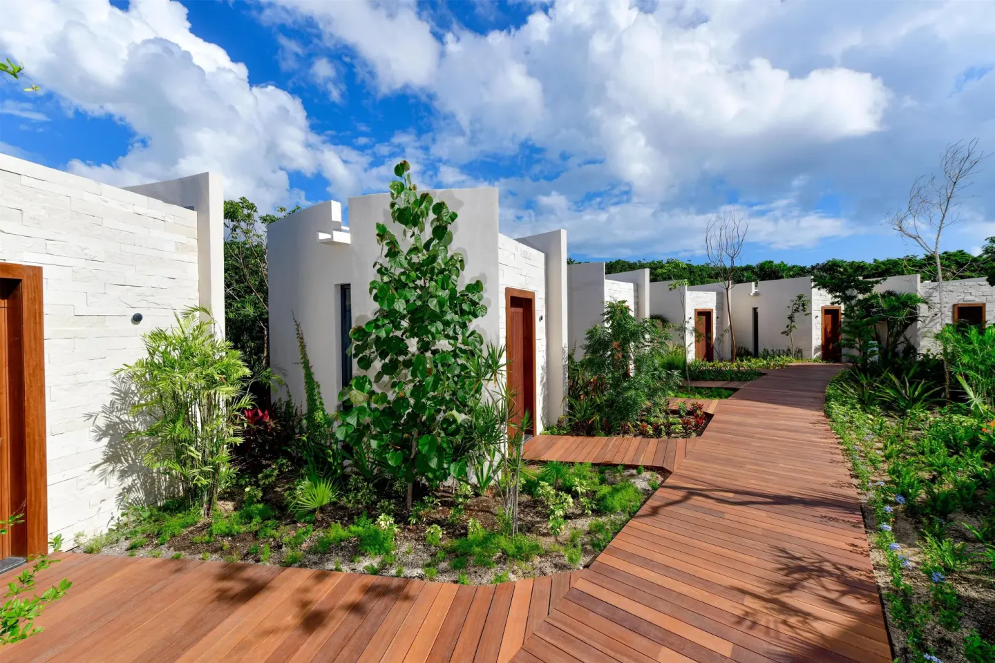 Garden walkway past white guest buildings at Conrad Tulum Riviera Maya.
