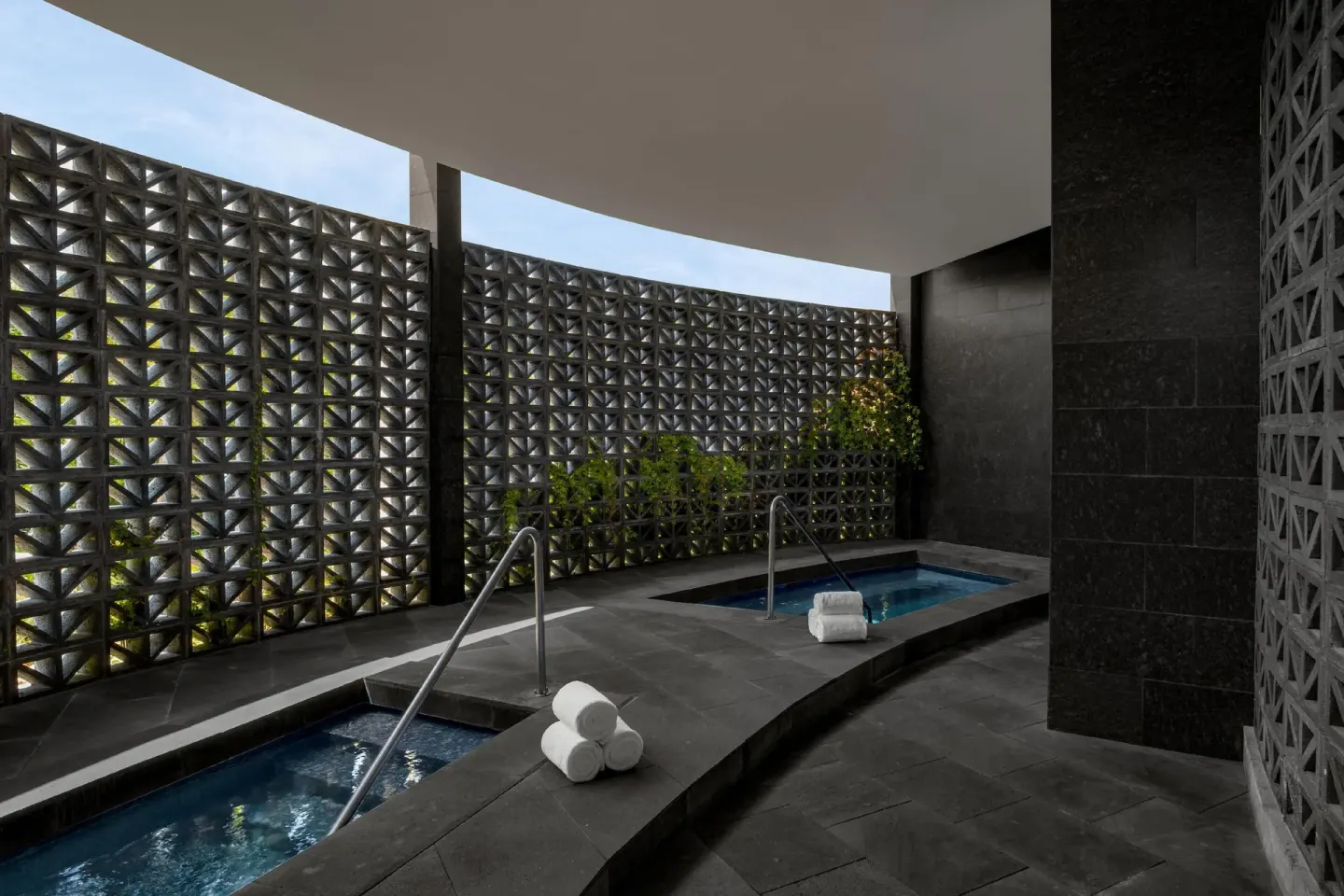 Indoor hydrotherapy pools with dark stone walls at Conrad Tulum Riviera Maya.