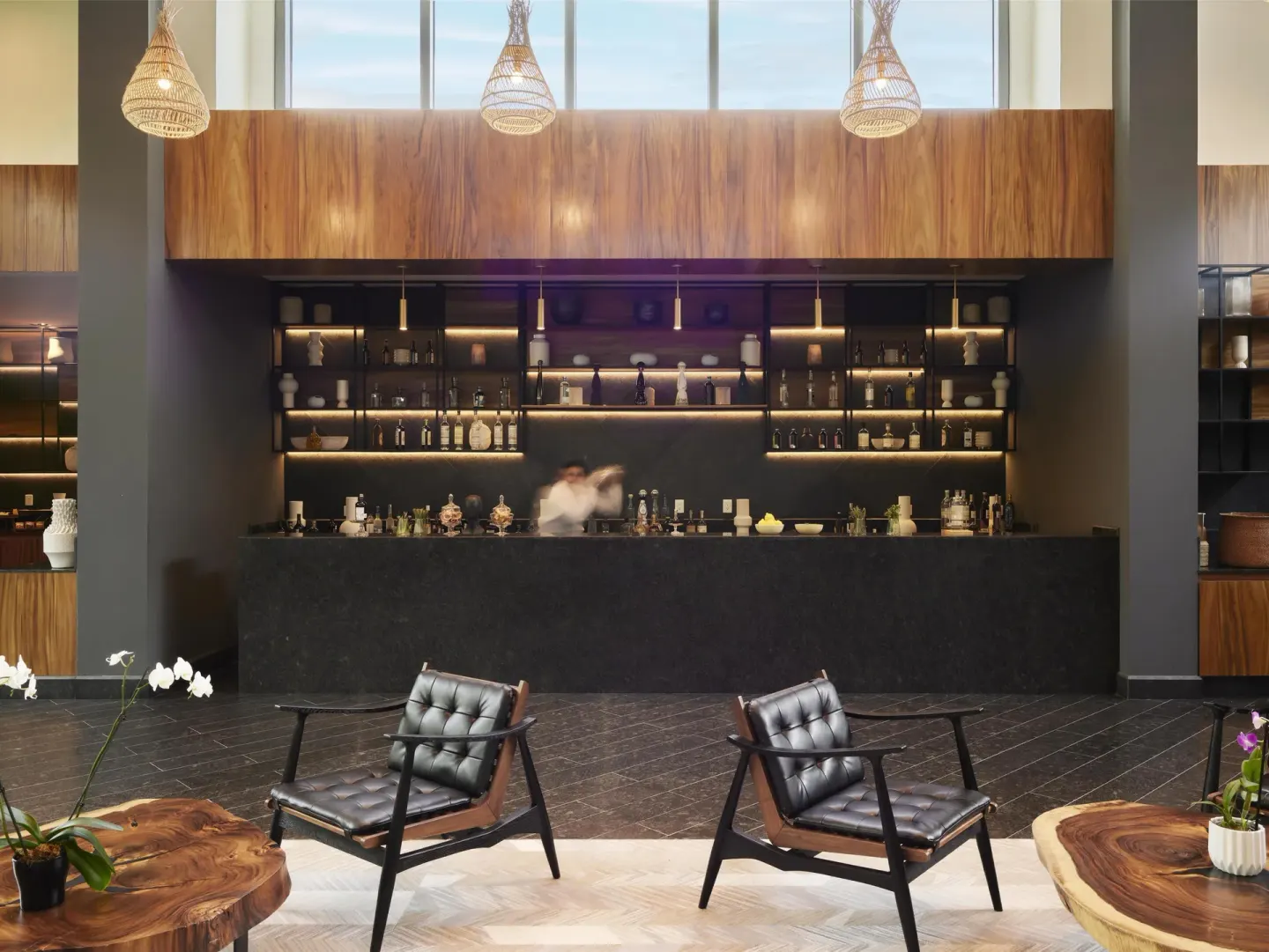 Lobby bar with lounge chairs and shelving at Conrad Tulum Riviera Maya.