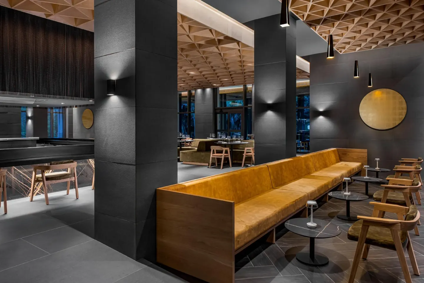 Lounge seating beside a dark restaurant at Conrad Tulum Riviera Maya.