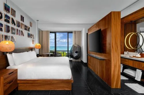 Ceiba Partial Ocean View Guestroom bed and balcony at Conrad Tulum Riviera Maya.