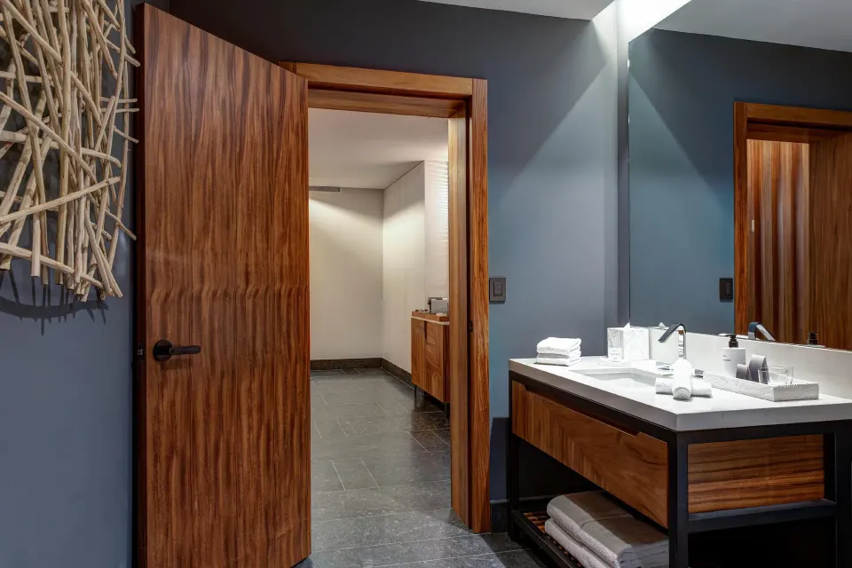 Ceiba Tropical View suite bathroom vanity and wood door at Conrad Tulum Riviera Maya