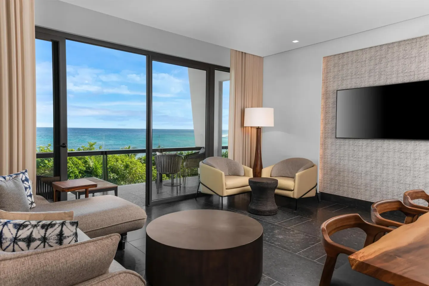 Ocean View Suite living room and balcony at Conrad Tulum Riviera Maya overlooking the sea.