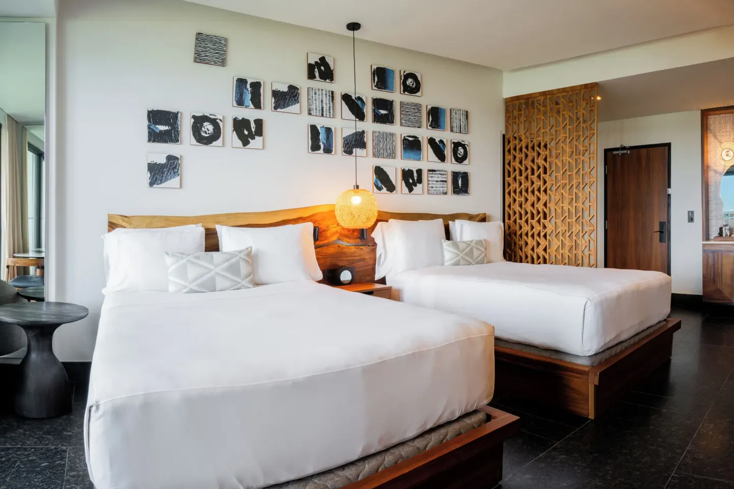 Two-bed Tropical View Guestroom at Conrad Tulum Riviera Maya with wood headboards and wall art.