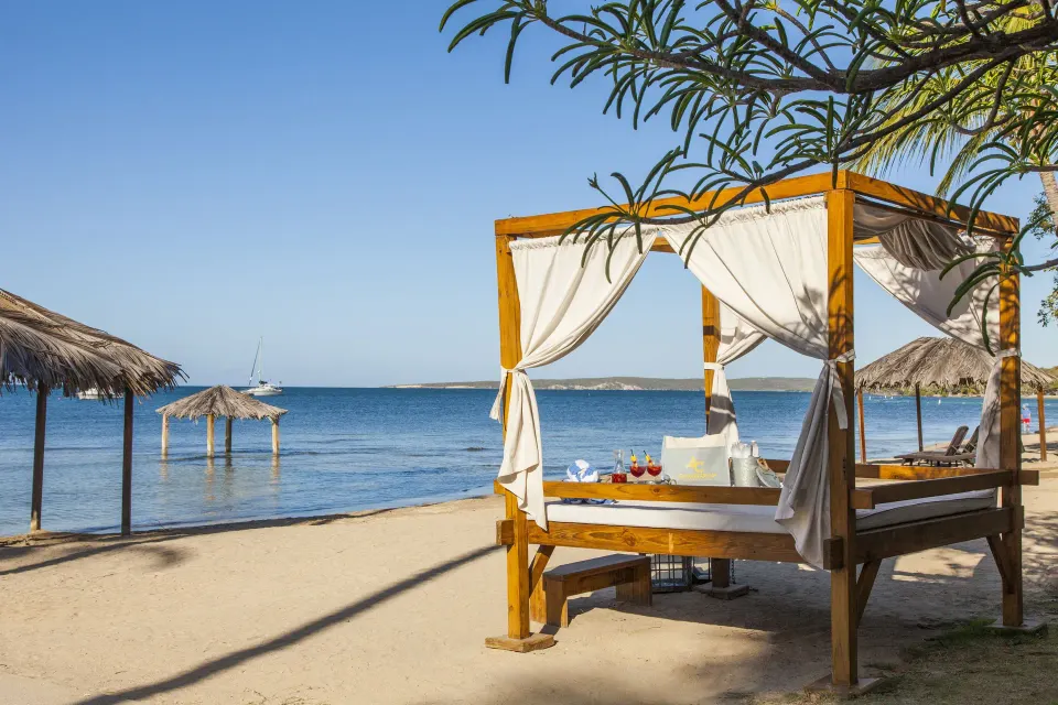 Beach cabana with white curtains beside the water at Copamarina Beach Resort & Spa.