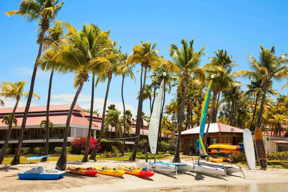 Kayaks, sailboats, and paddleboards on the beach at Copamarina Beach Resort & Spa.