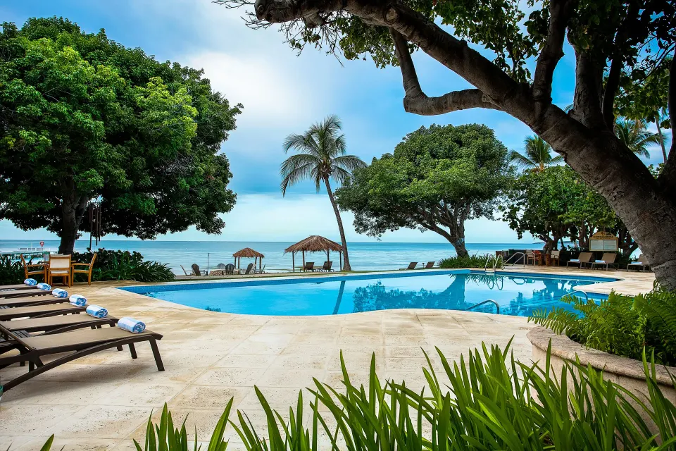 Beachfront pool with lounge chairs and ocean views at Copamarina Beach Resort & Spa.